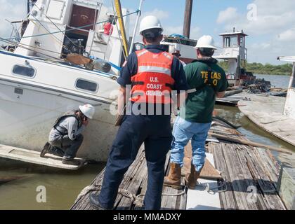 Un imprenditore da Laredo costruzione controlla la poppa di una recuperare cabinato mentre Petty Officer di terza classe Andrew Fleming, una scienza marina tecnico, e Texas terra generale Ufficio responsabile della risposta di Jesse Mayorga osservare. La Guardia Costiera e TGLO stanno lavorando con gli altri enti federali, statali e agenzie tribali per coordinare gli sforzi di recupero dopo il passaggio dell uragano Harvey. Stati Uniti Coast Guard foto di Chief Petty Officer John Masson. Foto Stock