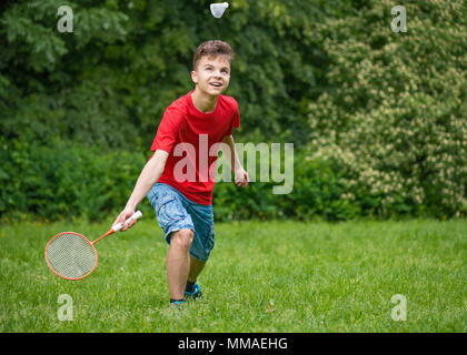 Teen boy playing badminton in posizione di parcheggio Foto Stock