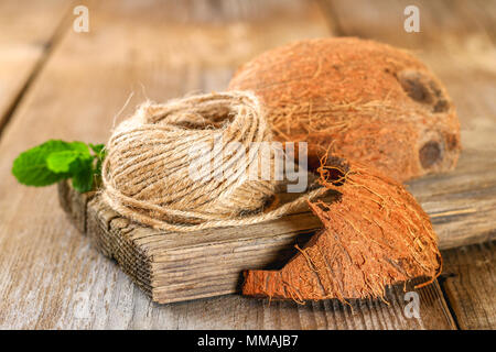 Corda di fibra di cocco e di guscio di noce di cocco su un vecchio tavolo in legno Foto Stock