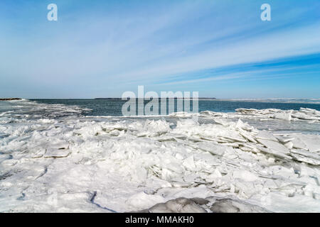 Il gelido freddo e la riva del lago Erie in Northwest Ohio. Grandi lastre di ghiaccio si accumulano vicino a te a riva come il vento rompe il ghiaccio. Foto Stock