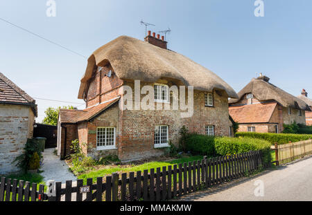 Attraente in mattoni rossi in stile locale cottage con il tetto di paglia / cottage in Oriente Stratton, un piccolo villaggio vicino a Winchester in Hampshire, Inghilterra meridionale Foto Stock