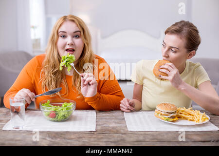 Contenuto plump donna a pranzo con il suo amico Foto Stock