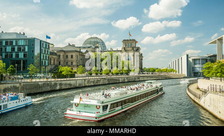 Barca sul fiume Sprea a Berlino con il Reichstag in background. Foto Stock