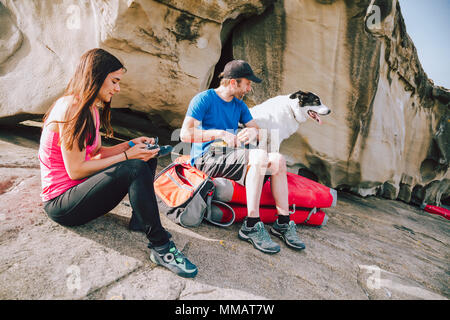 Coppia giovane di alpinisti con cane ottenere pronto per l'arrampicata Foto Stock