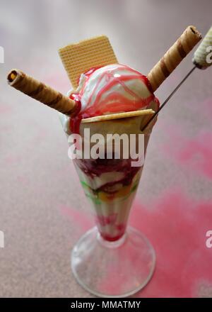 Una gloria kniccurbocker gelato con salsa di lamponi, cialde di wafer e Cannucce di cioccolato in un bicchiere alto al Ritz cafe a Millport, Scotland, Regno Unito Foto Stock