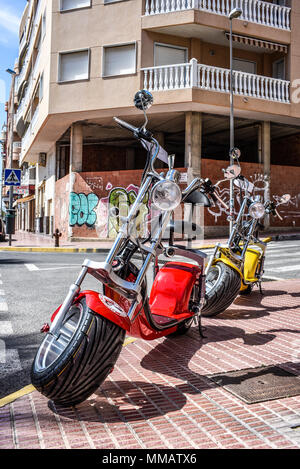 Lo scooter elettrico a noleggio. Affitto CB noleggio scooter moto. Colore luminoso biciclette elettriche sulla strada di Guardamar, Spagna. Spagnolo città Med Foto Stock