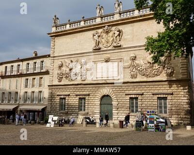 Set di artisti fino a vendere dipinti nella parte anteriore dei vecchi edifici sulla piazza di fronte al Palazzo dei Papi di Avignone, Francia Foto Stock