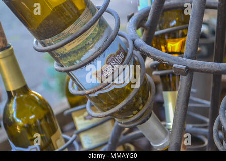 Rancho Bernardo in California - la più antica cantina di lavoro. Vintage scene arrugginita farm equipment per mulini a vento pigramente di filatura nella brezza. Fiori Foto Stock