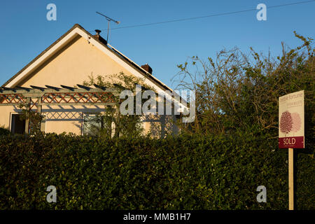 Un segno venduti da un locale North Somerset agenzia immobiliare al di fuori di un bungalow rurale, il 5 maggio 2018, Wrington, North Somerset, Inghilterra. Foto Stock