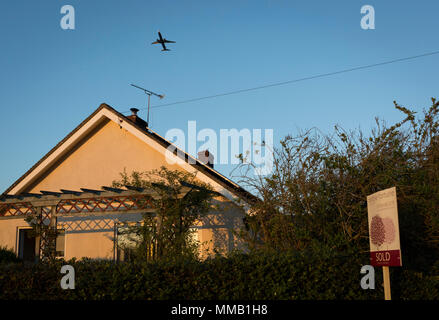 Un aereo jet in partenza dal vicino aeroporto di Bristol decollo da un bungalow Rurale, recentemente venduto da un locale North Somerset agenzia immobiliare, il 5 maggio 2018, Wrington, North Somerset, Inghilterra. Foto Stock