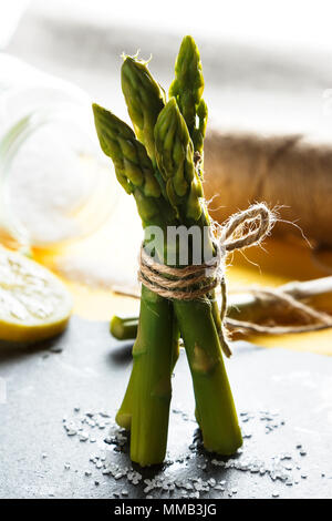 Gli asparagi. Mazzetto di freschi asparagi selvatici in piedi su una lastra di ardesia. Una sana alimentazione vegetariana. L'immagine verticale Foto Stock