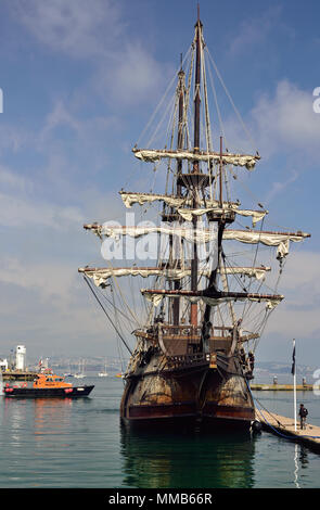 El Galeon Andalucia ormeggiato a Brixham in Devon, con il pilota del porto accanto a. Foto Stock