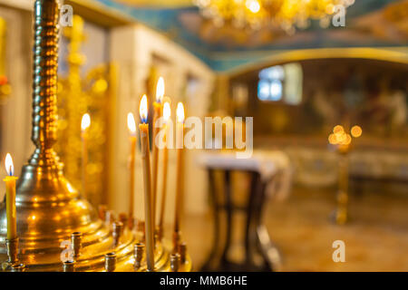 Candelabro con candele accese in chiesa. religione Foto Stock