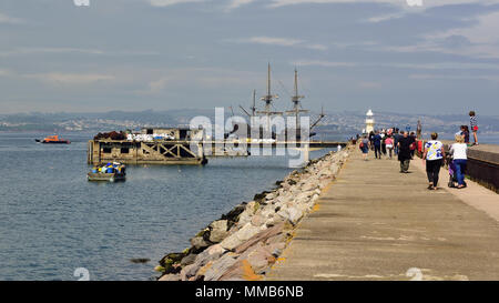 El Galeon Andalucia passando il vecchio molo di carburante e frangiflutti a Brixham in Devon dopo essere stati accompagnati in acqua aperta dal ritorno di barca pilota. Foto Stock