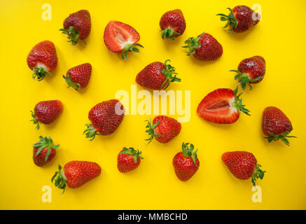 Red succose fragole luminoso su sfondo giallo. Foto Stock
