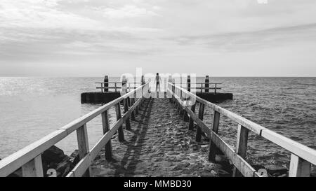 Ragazzo in piedi sul bordo Foto Stock