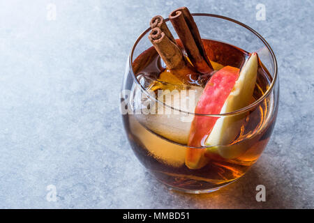 Sidro di mela Whiskey Cocktail con bastoncini di cannella, ghiaccio e fette di mela. Concetto di bevanda. Foto Stock