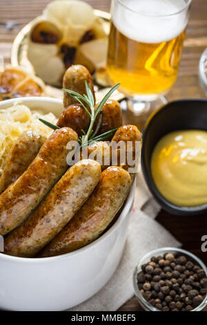 Salsicce alla griglia, cavolo, senape e birra Foto Stock