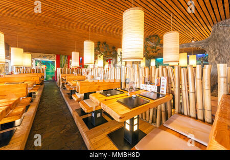 Mosca - Agosto 2014: Interno della I sushi giapponesi La cucina del ristorante della catena "TANUKI'. Una fila di tavoli in legno e panche Foto Stock