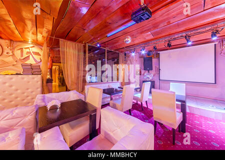 Mosca - Agosto 2014: Deluxe interior karaoke bar - "VINYL'. Camera decorata in uno stile Asiatico con una TV in bianco e arredi in pelle Foto Stock