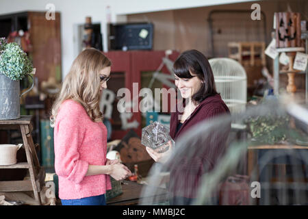 Due donne caucasici shopping in un negozio di antiquariato Foto Stock