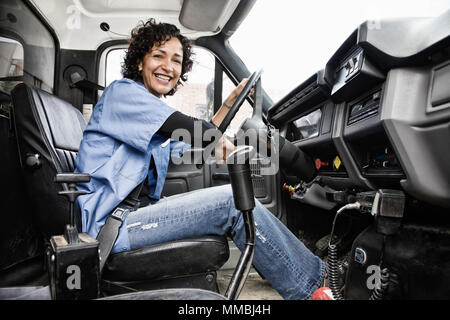 Donna ispanica camionista e azienda distribuzione carrello. Foto Stock