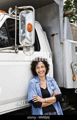 Donna ispanica camionista e azienda distribuzione carrello. Foto Stock