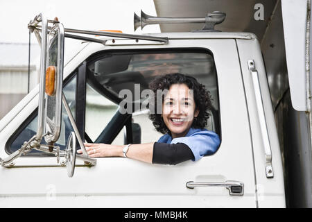 Donna ispanica camionista e azienda distribuzione carrello. Foto Stock