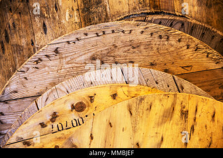 Chiusura del round di coperchi di legno riciclato in un magazzino. Foto Stock