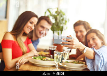 Gruppo di amici godendo di pasto in ristorante Foto Stock