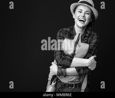 La ricerca di luoghi ispiratrice. Sorridendo viaggiatore attivo donna abbracciando uno zaino sullo sfondo Foto Stock