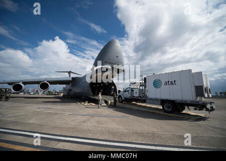 Master Sgt. Steve Brewer, un loadmaster assegnato al nono Airlift Squadron, Dover Air Force Base, Delaware, guida una AT&T torre di telecomunicazioni al di fuori di un C-5M Super galassia a Luis Muñoz Marín International Airport, Puerto Rico, 6 ott. 2017. Il C-5M trasportato torri da AT&T, per fornire copertura di telecomunicazione per le aree in Puerto Rico più colpiti dall uragano Maria. Si tratta di un'iniziativa del presidente Donald Trump le priorità per i tentativi di recupero in Puerto Rico. (U.S. Air Force foto di Tech. Sgt. Larry E. Reid Jr., rilasciato) Foto Stock