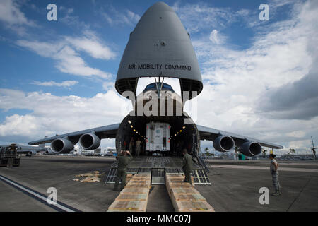 Master Sgt. Steve Brewer, un loadmaster assegnato al nono Airlift Squadron, Dover Air Force Base, Delaware, guida una AT&T torre di telecomunicazioni al di fuori di un C-5M Super galassia a Luis Muñoz Marín International Airport, Puerto Rico, 6 ott. 2017. Il C-5M trasportato torri da AT&T, per fornire copertura di telecomunicazione per le aree in Puerto Rico più colpiti dall uragano Maria. Si tratta di un'iniziativa del presidente Donald Trump le priorità per i tentativi di recupero in Puerto Rico. (U.S. Air Force foto di Tech. Sgt. Larry E. Reid Jr., rilasciato) Foto Stock