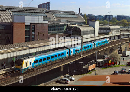 Su un bank holiday sabato un Arriva Trains Wales treno arriva alla stazione di Manchester Piccadilly con un servizio dall'aeroporto di Manchester a Llandudno. Foto Stock