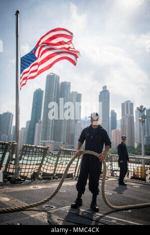 171006-N-TR141-0081 HONG KONG (ott. 6, 2017) Tecnico Sonar (Superficie) marinaio apprendista Rodolfo Melo, assegnato all'Arleigh Burke-class guidato-missile destroyer USS Chafee (DDG 90), gestisce la linea come la nave parte di Hong Kong, Cina. Chafee è parte dell'U.S. 3a flotta e U.S. Navale forze di superficie che è distribuito negli Stati Uniti 7 flotta area di operazioni su una distribuzione. (U.S. Navy combattere la foto della telecamera tramite la comunicazione di massa Specialist 1a classe Benjamin A. Lewis/rilasciato) Foto Stock