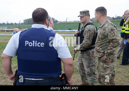 I poliziotti belgi lo scambio di informazioni con gli Stati Uniti Esercito militare poliziotto Sgt. Dustin Cardenas, terzo da sinistra, durante la sentinella scudo 2017, una scala piena di esercizio che esegue il test di collaborazione tra Stati Uniti Army Garrison Benelux, unità del locatario e i belgi agenzie civili, su Wingene Air Base, Belgio, Sett. 07, 2017. (U.S. Esercito foto di Visual Information Specialist Pierre-Etienne Courtejoie) Foto Stock