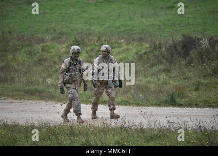 Due Stati Uniti Soldati a piedi intorno alla zona di caduta durante l'esercizio Risposta rapida 17 Fase II in corrispondenza del giunto multinazionale Centro Readiness Hohenfels, Germania, 10 ottobre, 2017. Risposta rapida 17, Fase II è un annuale, U.S. Esercito Europa-led è stata incentrata su allied Airborne Forces " possibilità di eseguire rapidamente e rispondere in modo efficace alle situazioni di crisi come una rete interoperabile multi-nazionale. L'esercizio avviene in corrispondenza della giunzione multinazionale Centro Readiness in Hohenfels, Germania, Ott 2-20, 2017 e include più di 7 mila partecipanti dalla Bosnia Erzegovina, Francia, Germania, Italia, Lituania, Paesi Bassi Foto Stock