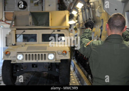 Un aviatore guide un esercito di Ohio National Guard Humvee su un C-17 Globemaster III ott. 11, 2017 a Rickenbacker Air National Guard Base in Columbus, Ohio. Circa 40 soldati del segnale 137azienda con sede a Newark, Ohio, stanno distribuendo a Puerto Rico per fornire supporto di comunicazioni per Hurricane Relief sforzi. (Ohio Guardia Nazionale foto di 1Lt. Aaron Smith) Foto Stock