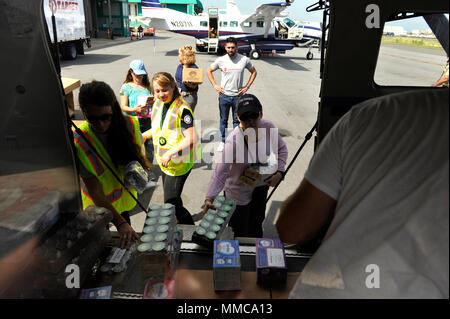 Glorimar Andújar, il segretario del Puerto Rico Dipartimento della famiglia, i soccorritori e volontari da Americorp, salvare i bambini e Puerto Rico sollievo volo carico di organizzazione per la cura di neonati in merci un piano in San Juan a essere volato a Vieques, Puerto Rico, dove gli articoli saranno distribuiti alle famiglie nella comunità interessate dall uragano Maria, Ottobre 12, 2017. La Federal Emergency Management Agency gli articoli forniti di raggiungere famiglie includono pannolini, pannolini per bambini, coperte, formula, bottiglie e ulteriore cura per neonati prodotti. Stati Uniti Coast Guard foto di Sottufficiali di 2a classe di Matteo S. Ma Foto Stock