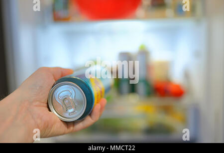 L'uomo prendendo lattina di birra dal frigo Foto Stock