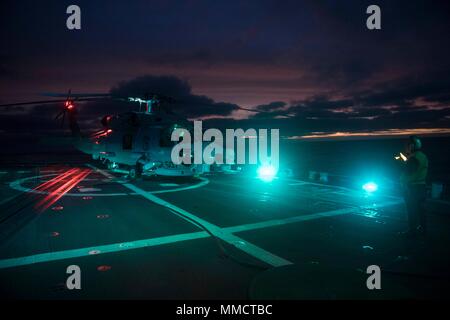 171006-N-IC246-0291 mare irlandese (ott. 6, 2017) di Boatswain mate 1. Classe James Sarkor, da Magnolia, Delaware, prepara un MH-60R Sea Hawk elicottero attaccato al "vipere" di elicottero Maritime Strike Squadron (HSM) 48, DET. 5, per il decollo a bordo del Arleigh Burke-class guidato-missile destroyer USS Winston S. Churchill (DDG 81) durante l'esercizio comune della Warrior 17-2, 6 ott. 2017. Joint Warrior è un REGNO UNITO-led, esercizio di multinazionali che sviluppa l'interoperabilità e la cooperazione in tutte le aree di guerra. (U.S. Foto di Marina di Massa Specialista comunicazione marinaio apprendista Raymond Maddocks Foto Stock