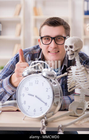 Studente e lo scheletro di preparazione per gli esami di scuola Foto Stock