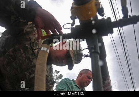 Citizen-Soldiers con il 714th Quartermaster Company, 191st regionale gruppo di supporto, da Puerto Rico Guardia Nazionale distribuiti acqua per la comunità della diocesi di Barahona nel comune di Morovis, Puerto Rico, Ott. 16. Le guardie sono arrivati con due veicoli recanti ciascuno 2,000 galloni di acqua purificata. (Foto di Spc. Agustín Montañez, PRNG-PAO/rilasciato) Foto Stock