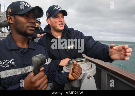 171013-N-FP878-024 OCEANO ATLANTICO (ott. 13, 2017) insegna camerunese Tchinde Etienne, sinistra riceve conning officer training dal tenente j.g. James Wickham a bordo del Arleigh Burke-class guidato-missile destroyer USS Donald Cook (DDG 75). Donald Cook è distribuito a Rota, Spagna, sulla sua sesta patrol NEGLI STATI UNITI Sesta flotta area di operazioni a sostegno degli enti regionali alleati e partner, e degli Stati Uniti gli interessi di sicurezza nazionali in Europa. (U.S. Foto di Marina di Massa lo specialista di comunicazione 1a classe Theron J. Godbold/rilasciato) Foto Stock