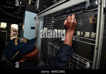 171016-N-UY653-161 OCEANO ATLANTICO (ott. 16, 2017) Ensign Teashla Moody scrive un messaggio motivazionale in pilothouse del Arleigh Burke-class guidato-missile destroyer USS Oscar Austin (DDG 79), il 16 ottobre, 2017. Oscar Austin è su di una routine di distribuzione negli Stati Uniti di supporto gli interessi di sicurezza nazionali in Europa e teatro aumentando la cooperazione in materia di sicurezza e di avanzamento presenza navale negli Stati Uniti Sesta flotta area di operazioni. (U.S. Foto di Marina di Massa lo specialista di comunicazione 2a classe Ryan Utah Kledzik/rilasciato) Foto Stock