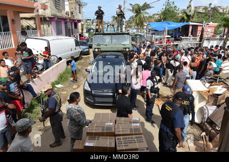 Più di 400 persone alluvione le strade di Canovanas, Puerto Rico, prima di ricevere il cibo e acqua da un gruppo misto di Coast Guard, FEMA, U.S. Esercito e Puerto Rico "Hacienda" ott. 17, 2017. Questo gruppo specifico è stata la distribuzione di acqua e pasti a regioni che hanno bisogno di più di venti giorni come parte di uragano in corso Maria i soccorsi. Coast Guard foto di Sottufficiali di prima classe Jon-Paul Rios. Foto Stock