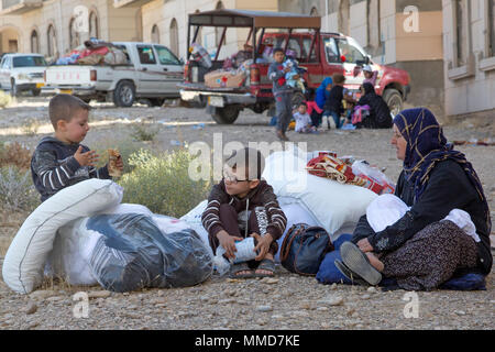 Un giovane ragazzo curdo mangia uno spuntino dopo aver ricevuto le forniture provenienti da un governo nazionale agenzia in modo da spostare in un fare-shift internamente sfollati persona accampamento presso il Kurdistan formazione Centro di coordinamento nei pressi di Erbil, Iraq, 19 ottobre 2017. (U.S. Esercito foto di Sgt. Tracy McKithern) Foto Stock