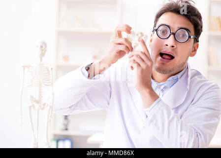 Crazy medico studiando scheletro umano Foto Stock