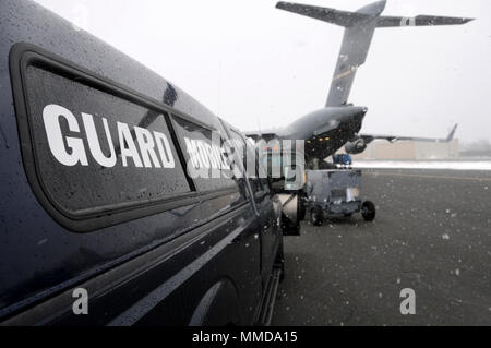 Membri assegnati alla 104th Fighter Wing, Massachusetts Air National Guard, attrezzature di carico su un C-17 Globemaster III, assegnato alla 445th Airlift Wing, Wright Patterson Air Force Base in Ohio. Il C-17 defunti Barnes Air National Guard Base, Marzo 14, 2018 come parte di un teatro Pacchetto di sicurezza in supporto del funzionamento Atlantic risolvere. Una volta che il teatro, il carico sarà inviato a più posizioni a sostegno di esercizi e di formazione con i nostri alleati e partner. (U.S. Air National Guard Foto Stock