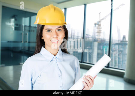 Un ingegnere donna azienda Mappa Progetto Immobiliare Sito in costruzione Foto Stock